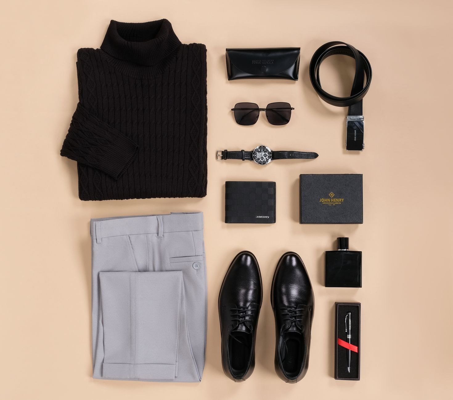 Light grey tailored trousers, a black turtleneck, black lace-up shoes and accessories arranged on a beige background.